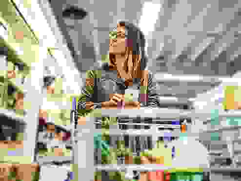 Shot of a young woman using a mobile phone in a grocery store